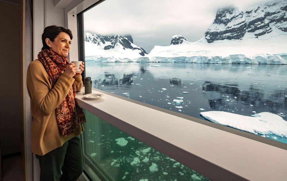 woman sipping from mug on cruise balcony in the glaciers